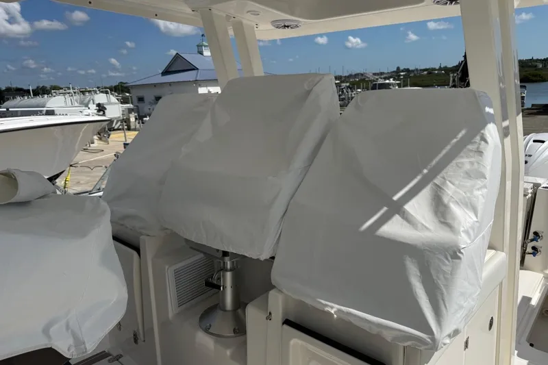 Slide: The Image of 2026 Pursuit S 358 Sport boat seats covered, docked under clear blue sky. - 30