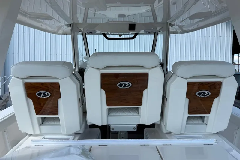 Slide: The Image of 2026 Pursuit S 358 Sport boat interior with three white and wood-accented seats. - 33