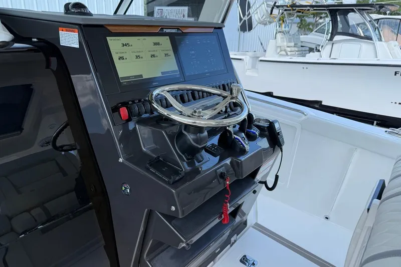 Slide: The Image of 2026 Pursuit S 358 Sport boat dashboard with steering wheel and digital display. - 35