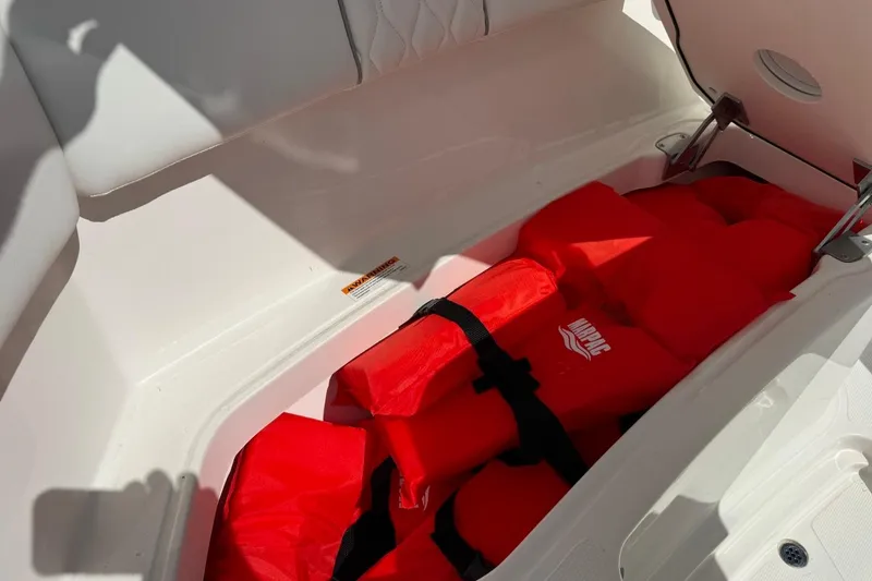 Slide: The Image of Storage compartment with red life jackets on a 2026 Pursuit S 358 Sport boat. - 43