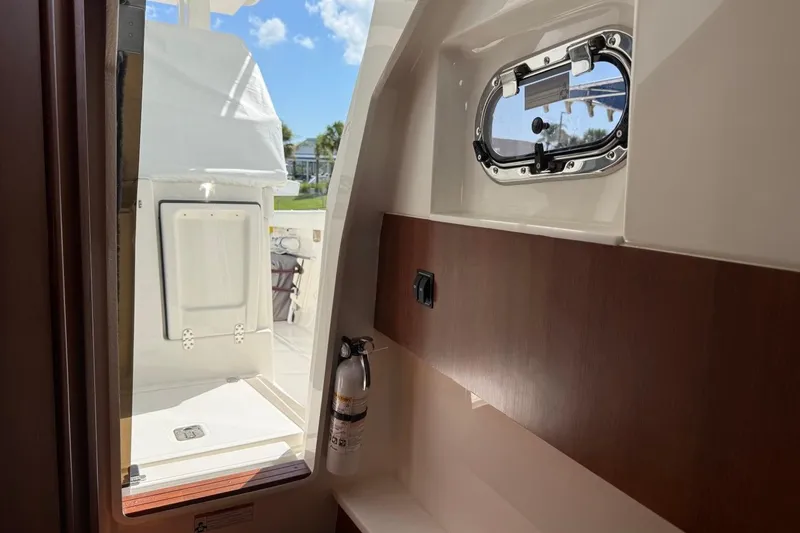 Slide: The Image of Interior view of 2026 Pursuit S 358 Sport boat, featuring a window and fire extinguisher. - 51