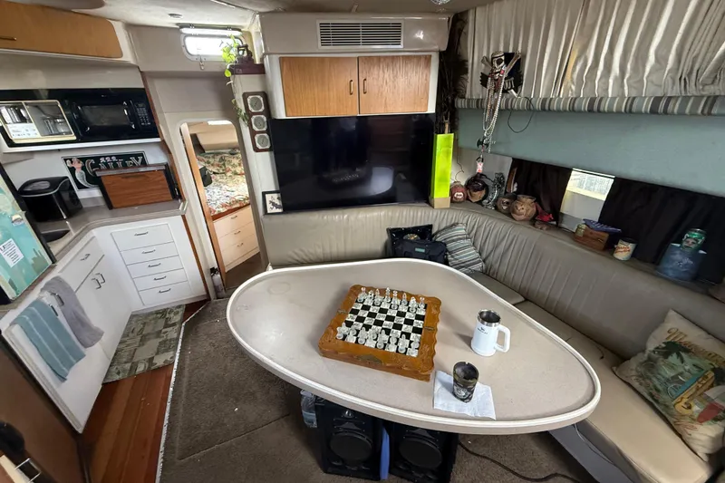Slide: The Image of Interior of 1995 Mainship 37 Motor Yacht with cozy seating and chessboard on table. - 10