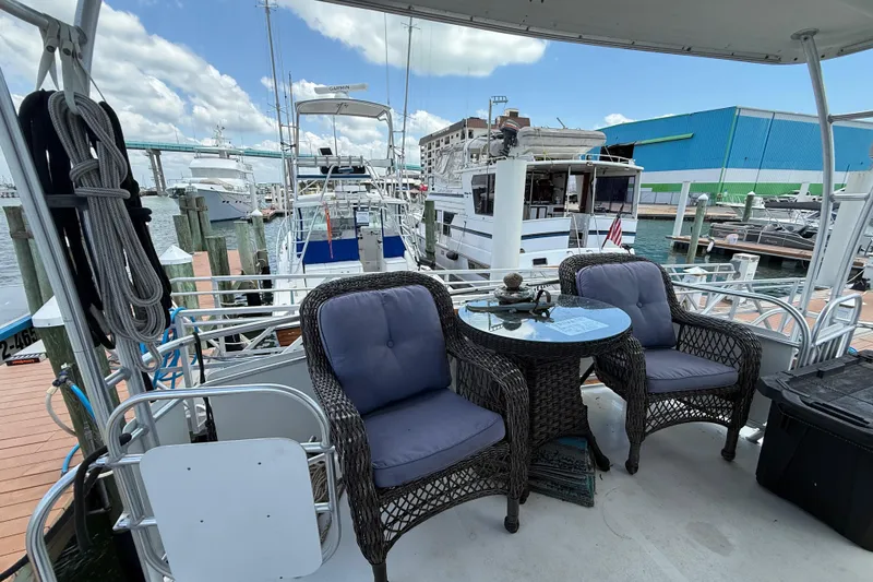 Slide: The Image of 1995 Mainship 37 Motor Yacht docked with wicker chairs and table on deck. - 11