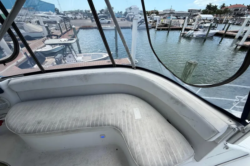 Slide: The Image of 1995 Mainship 37 Motor Yacht interior with marina view, featuring curved seating and clear windows. - 20