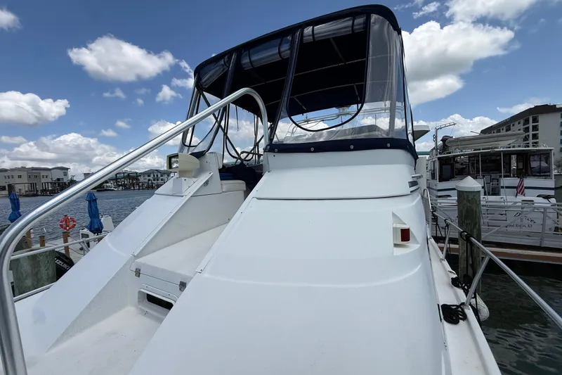 Slide: The Image of 1995 Mainship 37 Motor Yacht docked, featuring sleek design and spacious deck under a blue sky. - 21