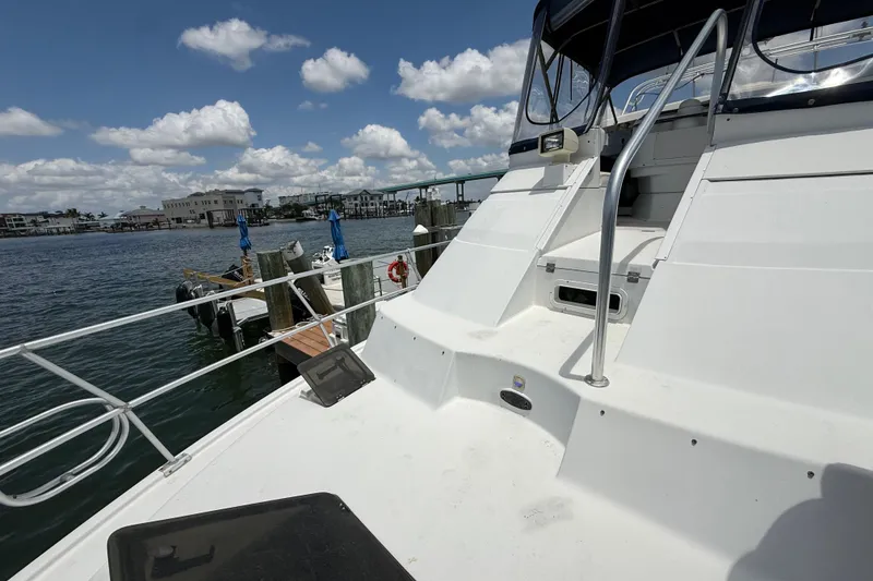 Slide: The Image of 1995 Mainship 37 Motor Yacht docked, featuring spacious deck and clear skies. - 24