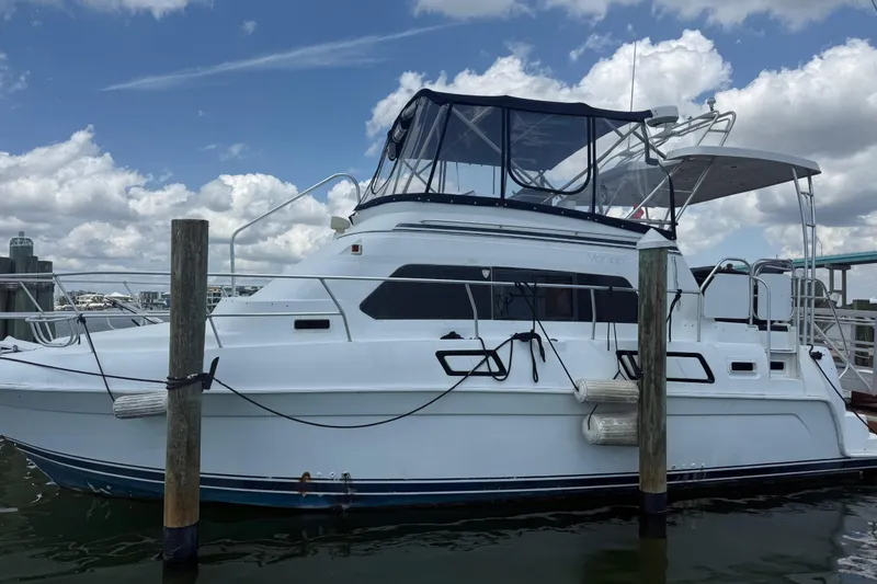 Slide: The Image of 1995 Mainship 37 Motor Yacht docked under a partly cloudy sky. - 27