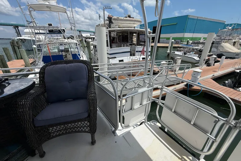 Slide: The Image of 1995 Mainship 37 Motor Yacht docked, featuring a wicker chair and marina view. - 7