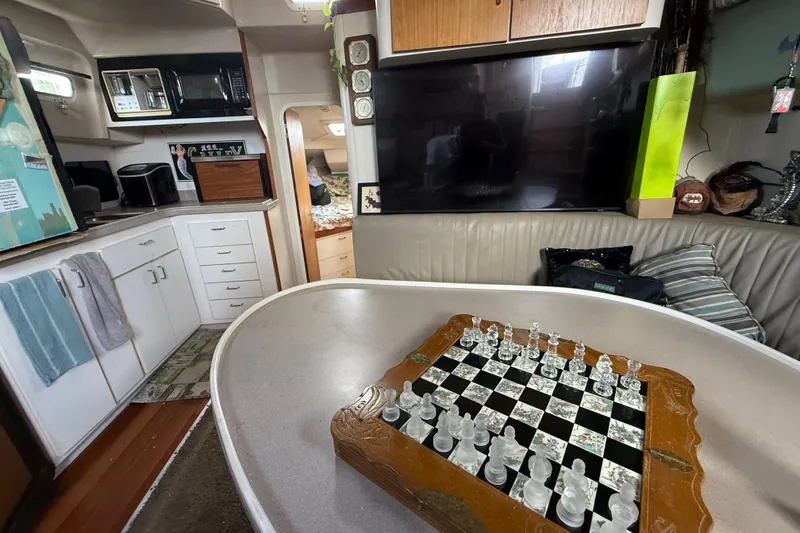 Slide: The Image of Interior of 1995 Mainship 37 Motor Yacht with chessboard, kitchenette, and seating area. - 8