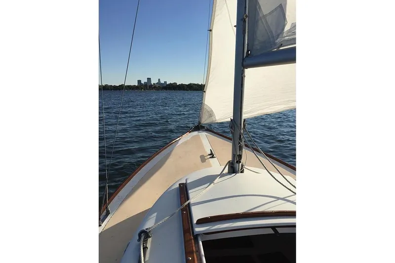 Slide: The Image of 1977 Cape Dory Typhoon Weekender sailboat on calm water with city skyline in background. - 3