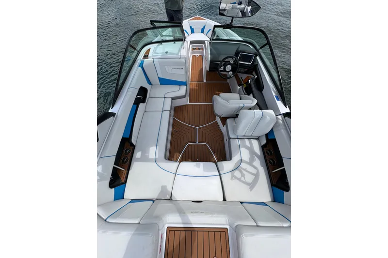 Slide: The Image of 2014 Nautique Super Air Nautique 210 boat interior with white seating and wooden flooring. - 7