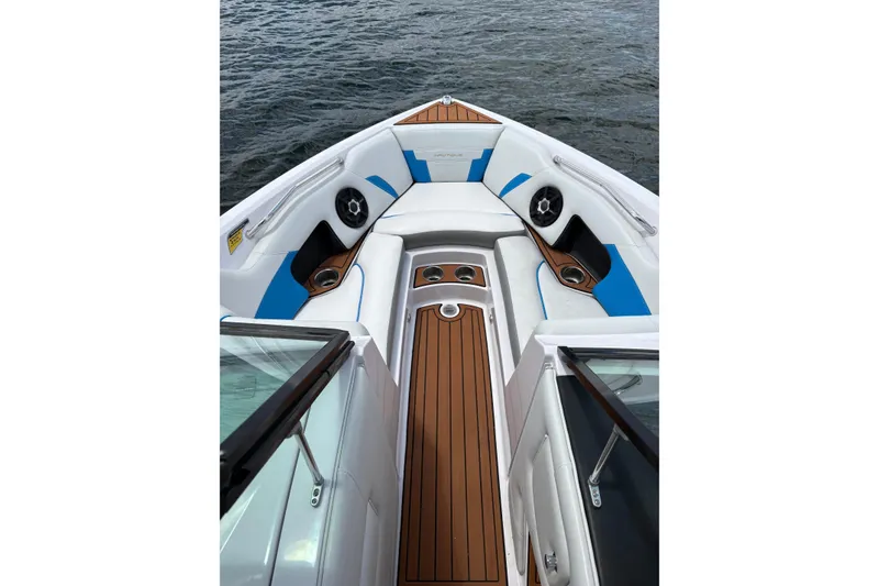 Slide: The Image of 2014 Nautique Super Air Nautique 210 boat interior with blue accents and wood flooring. - 8