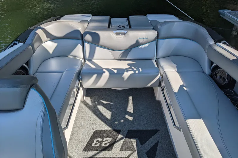 Slide: The Image of 2018 MasterCraft XT23 boat interior with gray seating and carpeted flooring. - 3