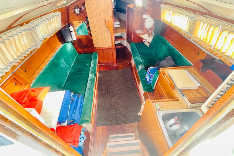 Slide: The Image of Interior of a 1982 Newport 28 sailboat with green seating and wooden cabinetry. - 3