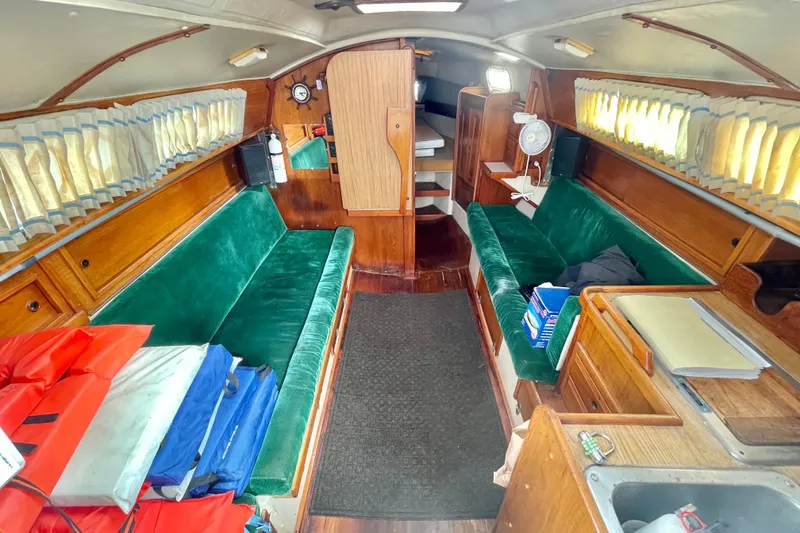 Slide: The Image of Interior of a 1982 Newport 28 sailboat with green seating and wooden cabinetry. - 4
