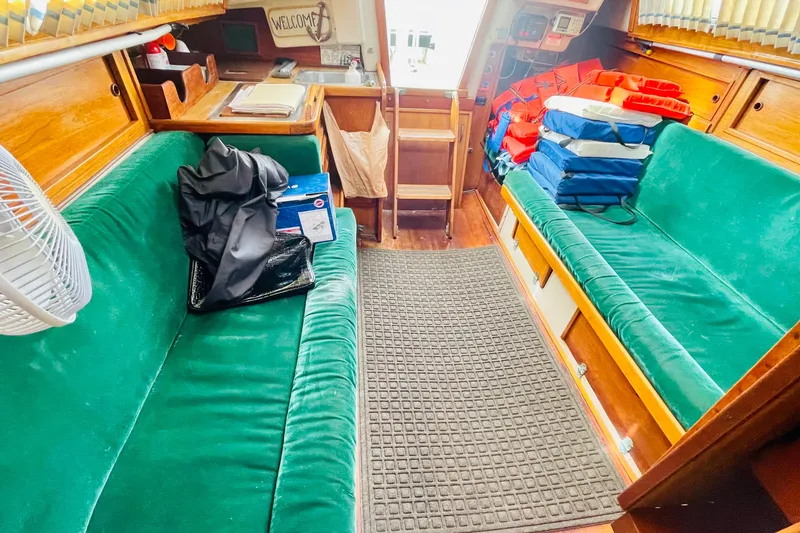 Slide: The Image of Interior of a 1982 Newport 28 sailboat with green seating and life jackets. - 5