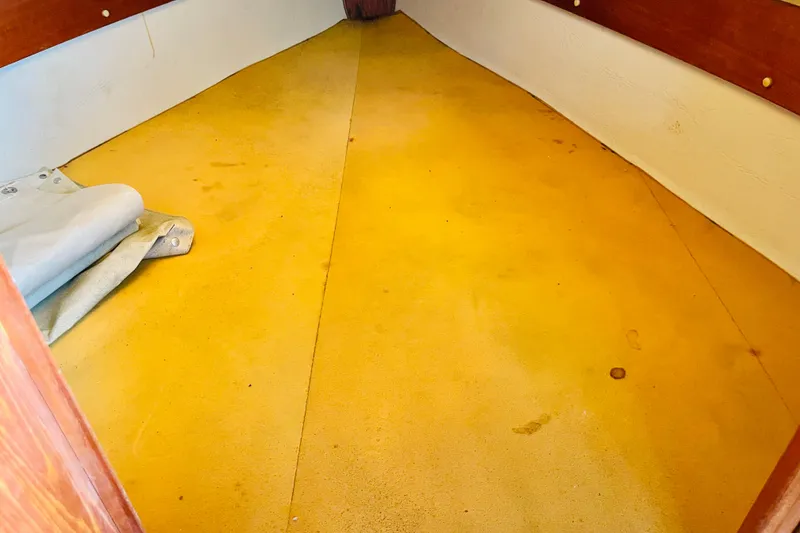 Slide: The Image of Interior view of a 1982 Newport 28 sailboat cabin with yellow flooring. - 6
