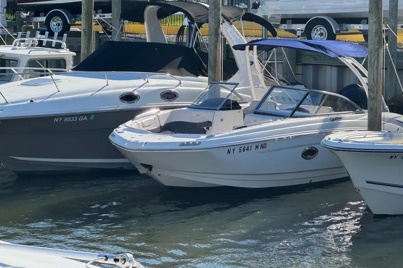 The Image of 2018 Chaparral 250 Suncoast boat docked among other vessels at a marina. - 0