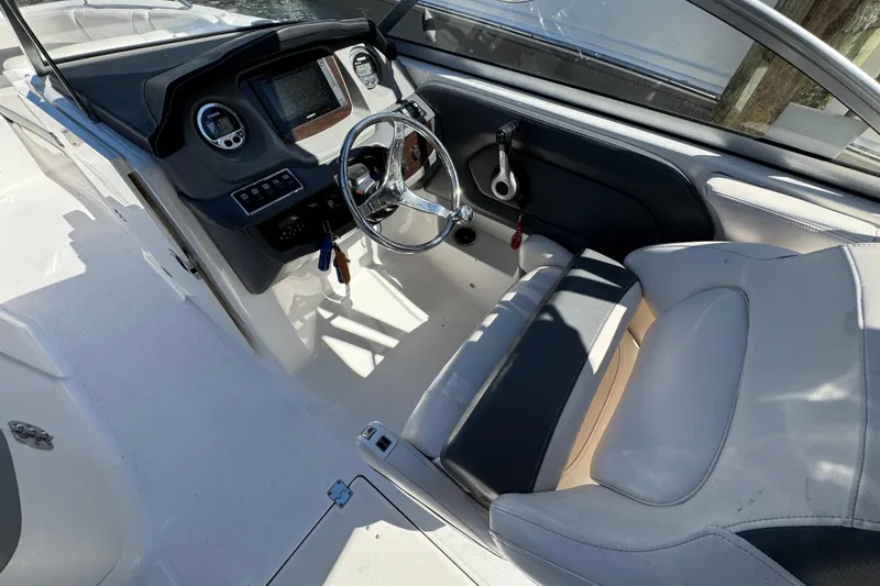 Slide: The Image of 2018 Chaparral 250 Suncoast boat cockpit with steering wheel and dashboard controls. - 10