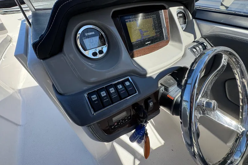 Slide: The Image of 2018 Chaparral 250 Suncoast dashboard with steering wheel and navigation display. - 14