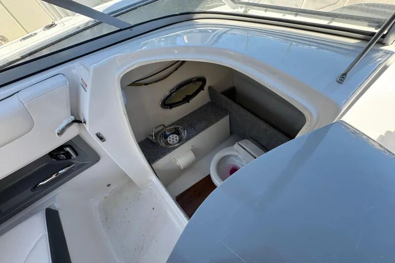 Slide: The Image of 2018 Chaparral 250 Suncoast boat interior with compact bathroom amenities. - 16