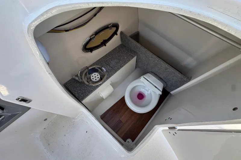Slide: The Image of 2018 Chaparral 250 Suncoast boat interior with compact bathroom and toilet. - 18