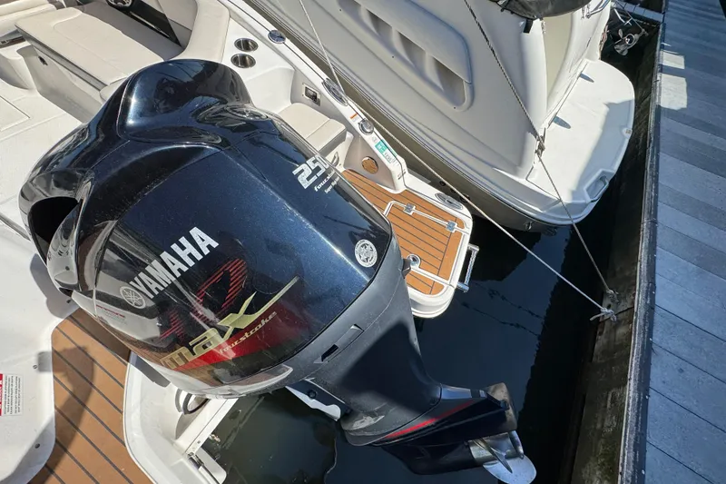 Slide: The Image of 2018 Chaparral 250 Suncoast with Yamaha outboard motor docked at marina. - 2