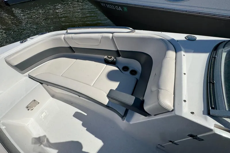 Slide: The Image of 2018 Chaparral 250 Suncoast boat interior with cushioned seating and cup holders. - 21