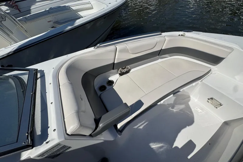 Slide: The Image of 2018 Chaparral 250 Suncoast boat interior with cushioned seating and cup holders. - 22