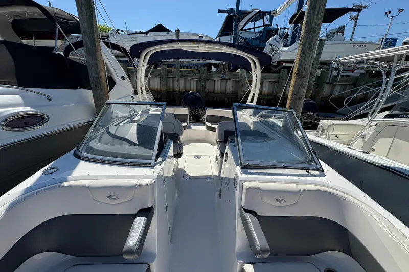 Slide: The Image of 2018 Chaparral 250 Suncoast boat docked, featuring dual windshields and spacious seating. - 26
