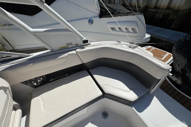 Slide: The Image of 2018 Chaparral 250 Suncoast boat interior with white seating and sleek design. - 7