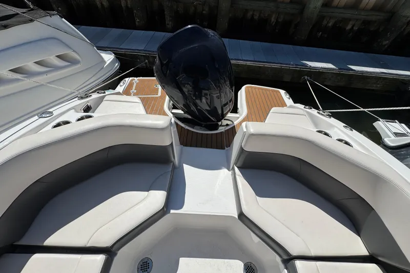 Slide: The Image of 2018 Chaparral 250 Suncoast boat interior with seating and outboard motor. - 8