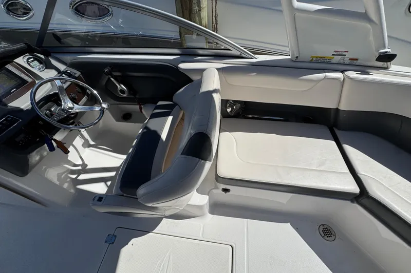 Slide: The Image of 2018 Chaparral 250 Suncoast boat interior with steering wheel and seating area. - 9