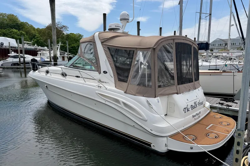 The Image of 2003 Sea Ray 340 Sundancer docked in a marina, featuring a tan canopy. - 0