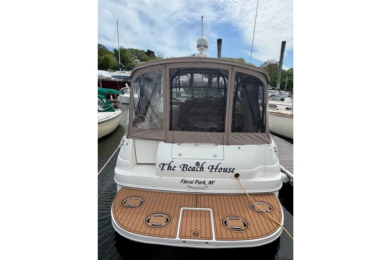 Slide: The Image of 2003 Sea Ray 340 Sundancer docked, featuring "The Beach House" name and covered cockpit. - 1