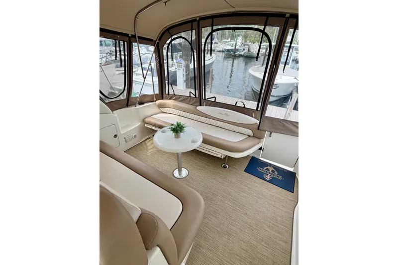 Slide: The Image of Interior of 2003 Sea Ray 340 Sundancer yacht with seating and table, dockside view. - 4