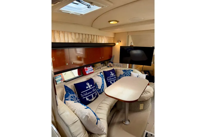 Slide: The Image of Interior of 2003 Sea Ray 340 Sundancer with cozy seating and nautical decor. - 8