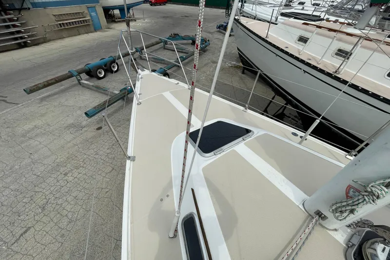 Slide: The Image of 1988 Catalina 30 sailboat on dry dock, showcasing deck and rigging details. - 14