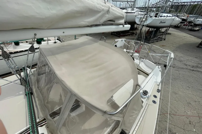 Slide: The Image of 1988 Catalina 30 sailboat with beige canopy, docked in a marina. - 17