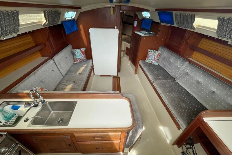 Slide: The Image of Interior of a 1988 Catalina 30 sailboat with cozy seating and kitchenette. - 19