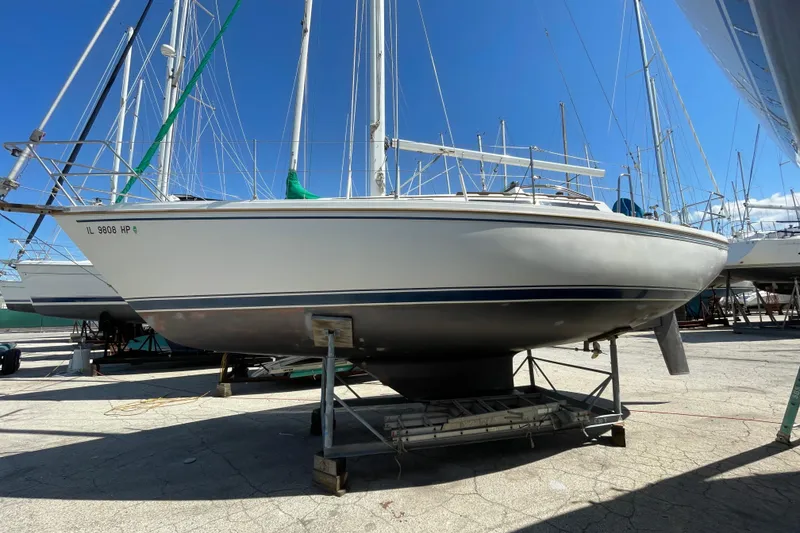 Slide: The Image of 1988 Catalina 30 sailboat on dry dock under clear blue sky. - 2