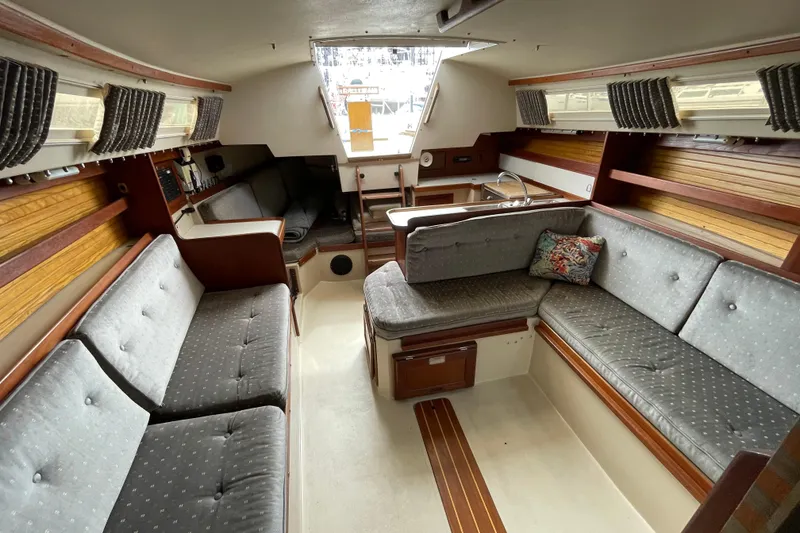 Slide: The Image of Interior of a 1988 Catalina 30 sailboat with cozy seating and wood accents. - 27