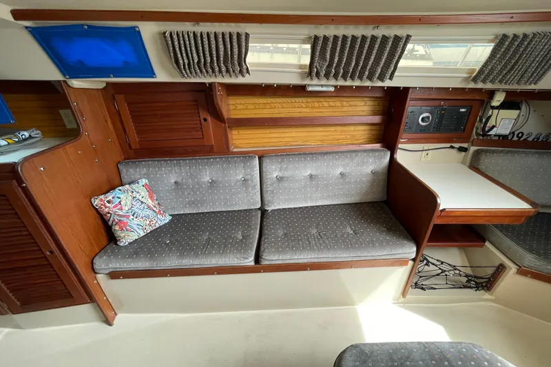 Slide: The Image of Interior of a 1988 Catalina 30 sailboat with gray seating and wooden accents. - 29