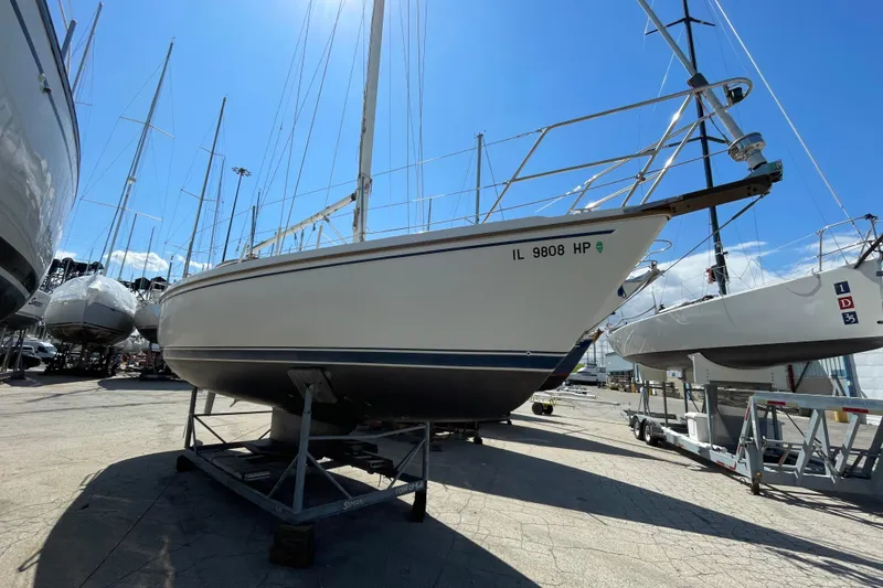 Slide: The Image of 1988 Catalina 30 sailboat on dry dock under clear blue sky. - 6