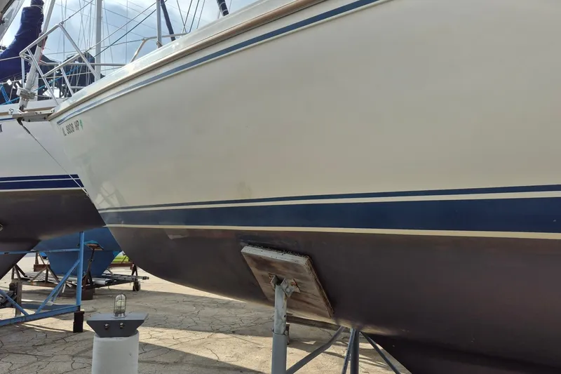 Slide: The Image of 1988 Catalina 30 sailboat on stands, showcasing hull and blue stripe design. - 7