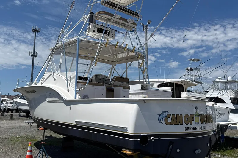 The Image of 2000 Dawson Yachts Express boat on land, featuring fishing equipment and "Can of Worms" branding. - 0
