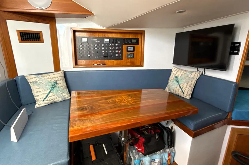 Slide: The Image of Interior of 2000 Dawson Yachts Express with wooden table, blue seating, and control panel. - 16