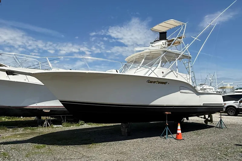 Slide: The Image of 2000 Dawson Yachts Express boat on land, clear sky background. - 2
