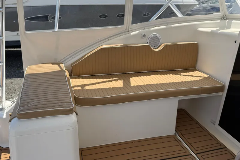 Slide: The Image of 2000 Dawson Yachts Express interior with tan cushioned seating and wood-patterned flooring. - 25