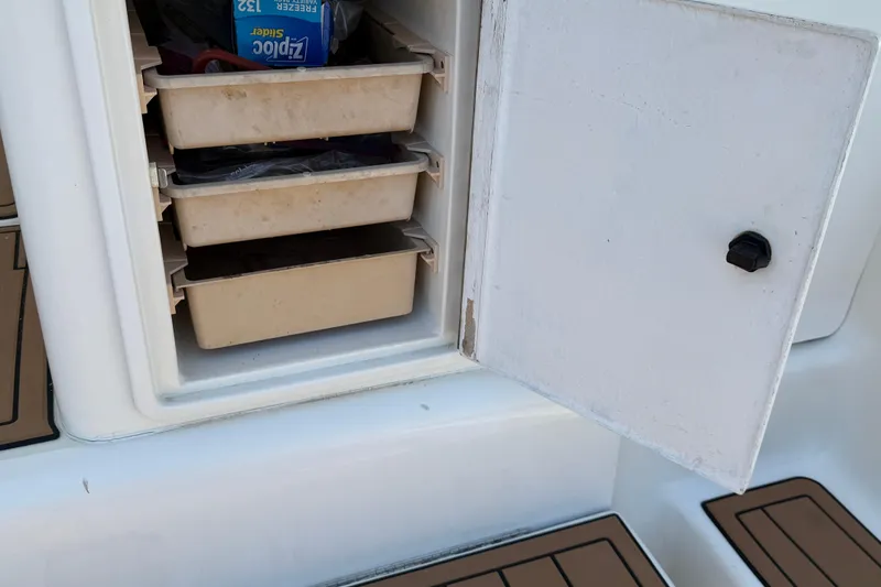 Slide: The Image of Open storage compartment on 2000 Dawson Yachts Express, featuring organized trays and a Ziplock bag. - 29
